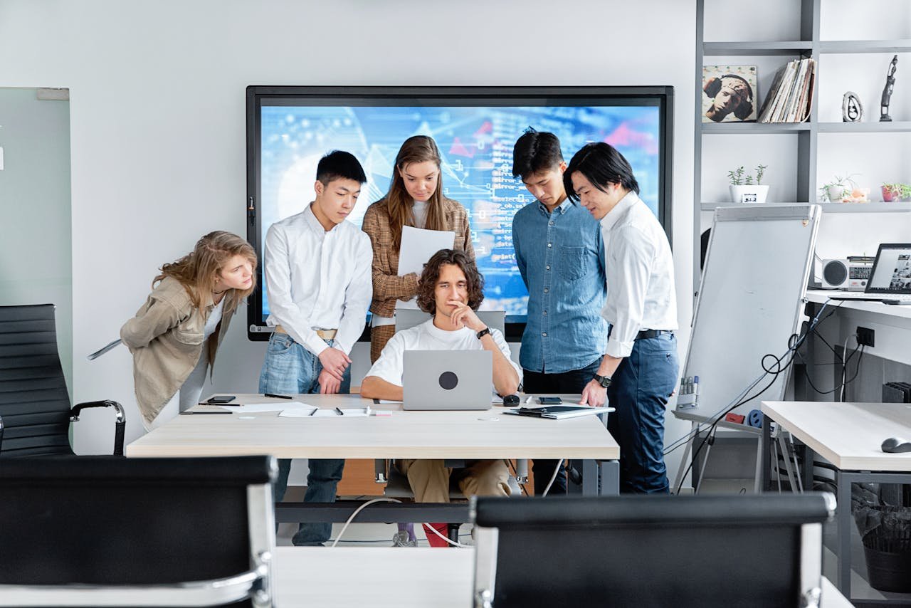 Diverse team collaborating on a software project in a contemporary office setting.